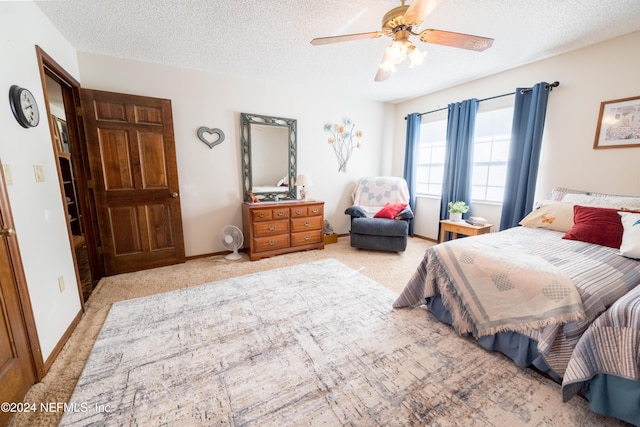 carpeted bedroom with a textured ceiling and ceiling fan