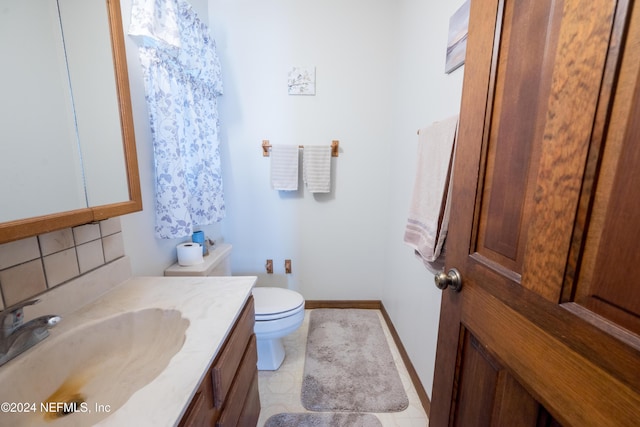 bathroom featuring tile patterned floors, vanity, toilet, and backsplash