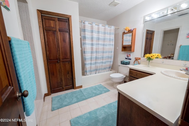 full bathroom with shower / bath combo, tile patterned flooring, a textured ceiling, toilet, and vanity