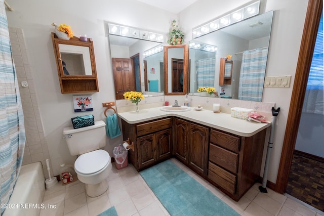 full bathroom featuring tile patterned flooring, vanity, toilet, and shower / bath combo with shower curtain