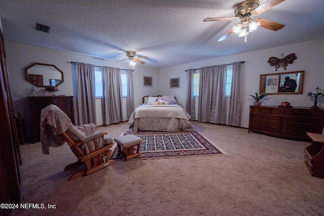 carpeted bedroom featuring ceiling fan and a textured ceiling