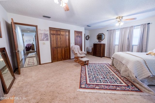 bedroom with light carpet, a textured ceiling, and ceiling fan