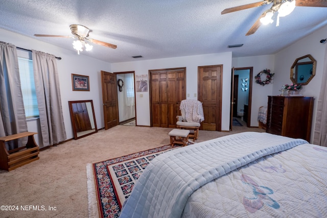 bedroom featuring ceiling fan, light colored carpet, and a textured ceiling