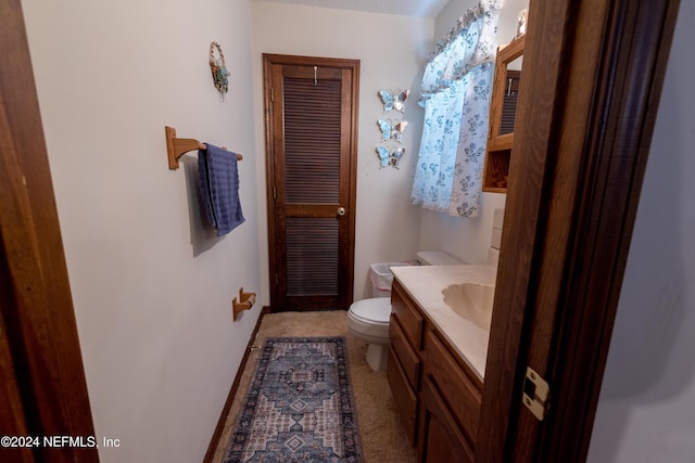 bathroom featuring vanity, a textured ceiling, and toilet