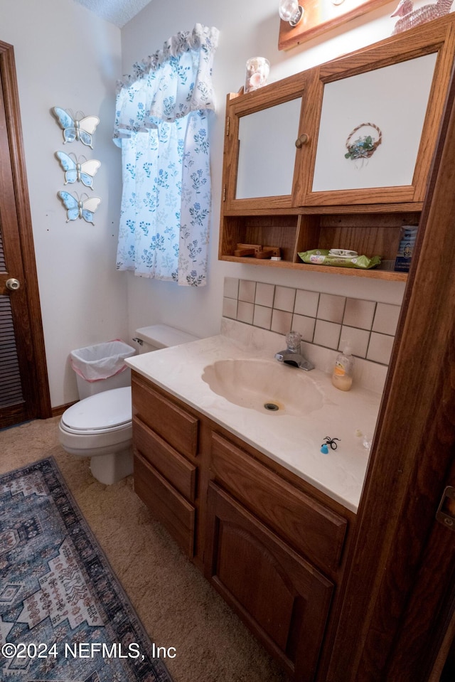 bathroom featuring decorative backsplash, vanity, and toilet