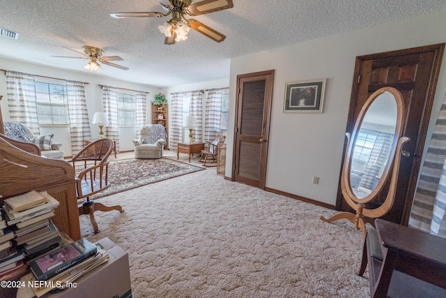 interior space with ceiling fan, carpet, and a textured ceiling