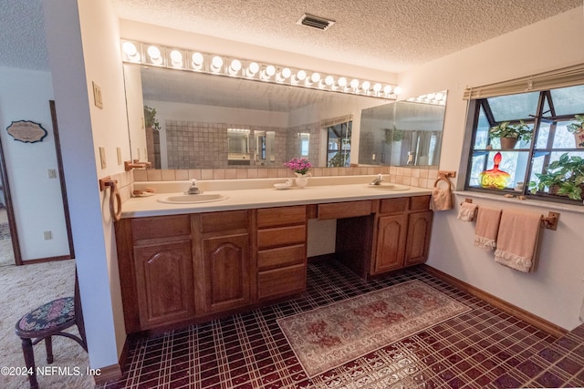 bathroom featuring tile patterned floors, vanity, and a textured ceiling