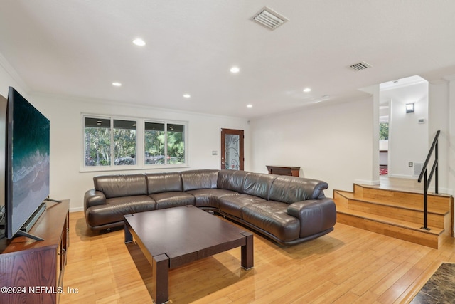 living room with crown molding and light hardwood / wood-style flooring