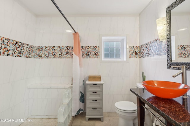 bathroom featuring tile patterned flooring, vanity, tile walls, and toilet