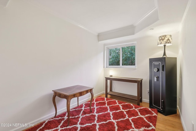 living area featuring hardwood / wood-style floors and crown molding