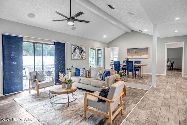 living room with hardwood / wood-style flooring, lofted ceiling with beams, a healthy amount of sunlight, and a textured ceiling