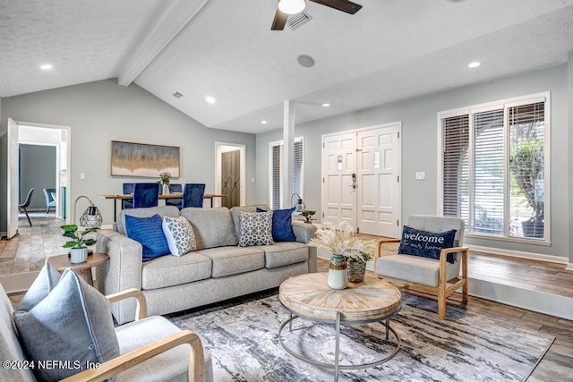 living room with hardwood / wood-style floors, vaulted ceiling with beams, a textured ceiling, and ceiling fan