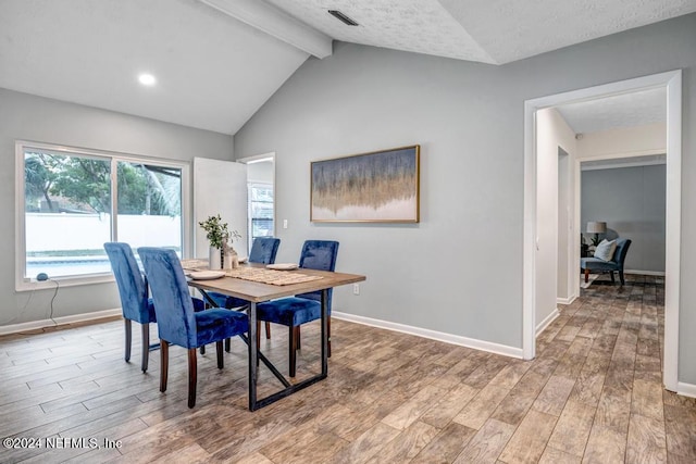 dining room featuring vaulted ceiling with beams and wood-type flooring