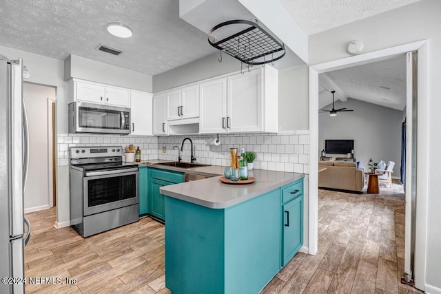 kitchen featuring appliances with stainless steel finishes, white cabinetry, ceiling fan, and sink