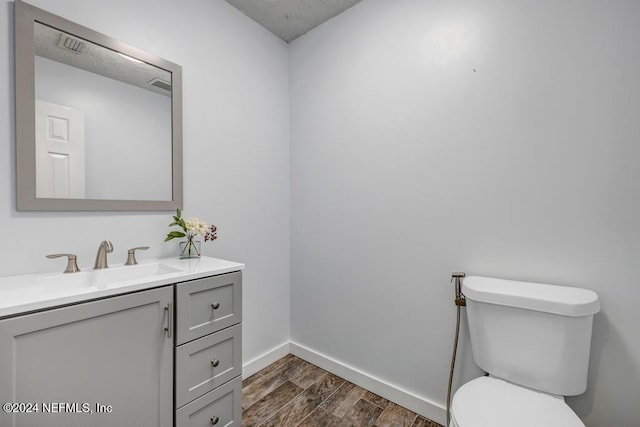 bathroom featuring vanity, toilet, and wood-type flooring