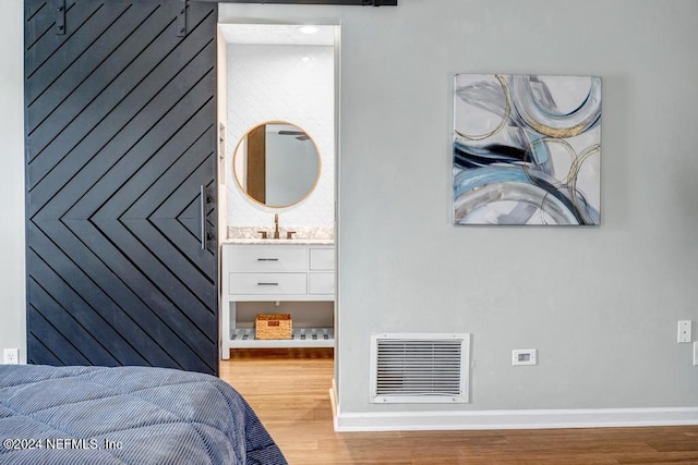 bedroom featuring sink and hardwood / wood-style flooring