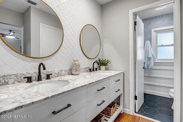 bathroom featuring tasteful backsplash, ceiling fan, hardwood / wood-style floors, and vanity