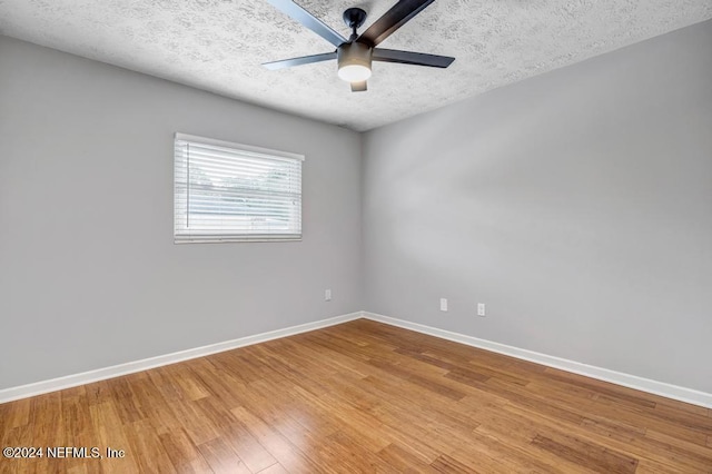 empty room featuring ceiling fan, a textured ceiling, and hardwood / wood-style flooring