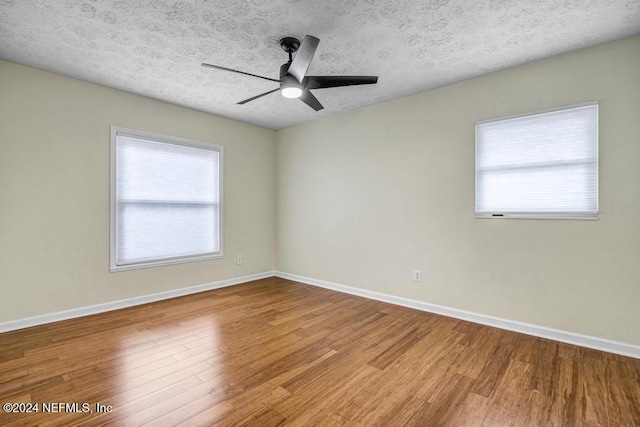 spare room featuring plenty of natural light, a textured ceiling, and hardwood / wood-style flooring