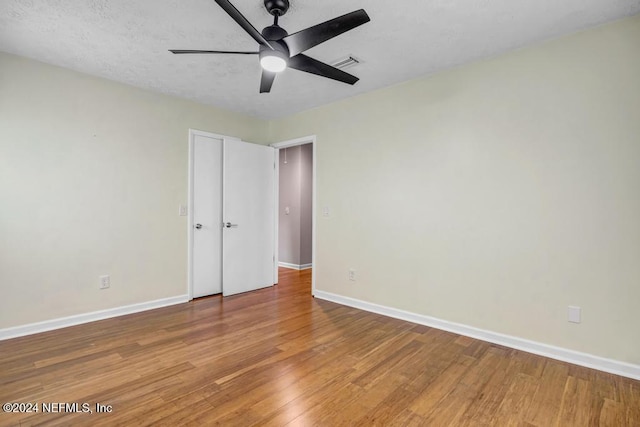 spare room with ceiling fan, wood-type flooring, and a textured ceiling