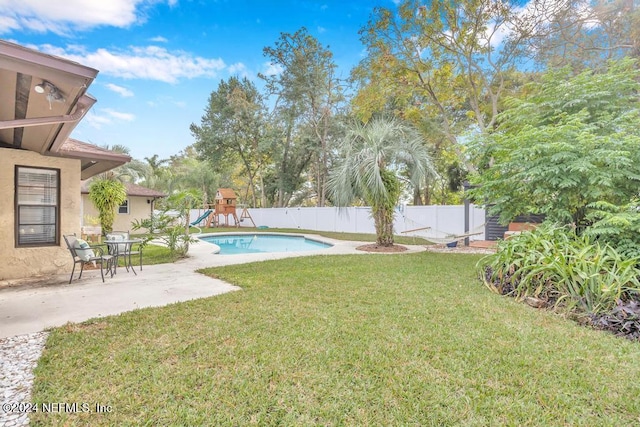 view of yard featuring a playground and a fenced in pool