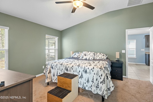 bedroom featuring lofted ceiling, ceiling fan, multiple windows, and light carpet