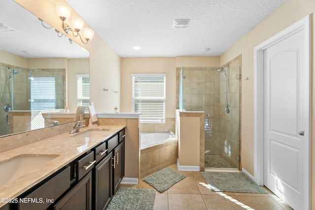 bathroom with vanity, separate shower and tub, tile patterned flooring, and a textured ceiling