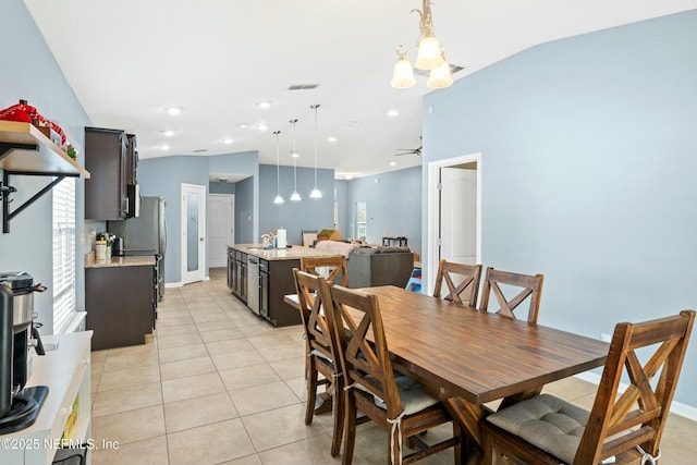 tiled dining room featuring ceiling fan, lofted ceiling, and sink