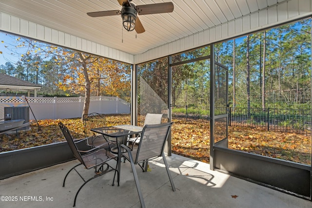 unfurnished sunroom featuring ceiling fan