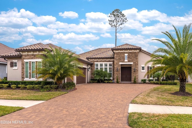 mediterranean / spanish-style house with a garage and a front lawn