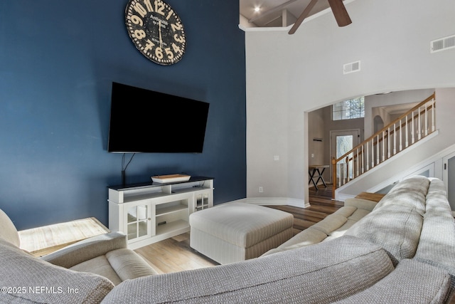 living room with hardwood / wood-style floors and high vaulted ceiling