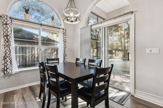 dining area featuring wood-type flooring and a chandelier