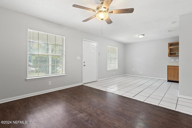 interior space with ceiling fan, light hardwood / wood-style floors, and a textured ceiling