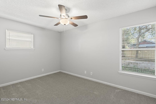 carpeted empty room featuring ceiling fan and a textured ceiling