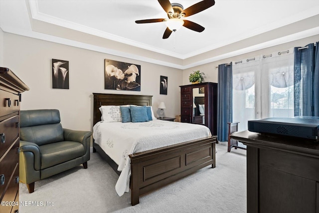 bedroom with light colored carpet, a raised ceiling, ceiling fan, and ornamental molding