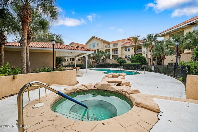 view of swimming pool with a patio area and a hot tub