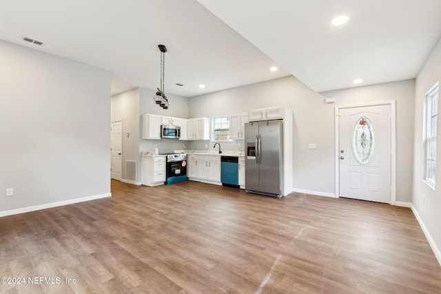 kitchen featuring a wealth of natural light, white cabinets, stainless steel appliances, and light wood-type flooring