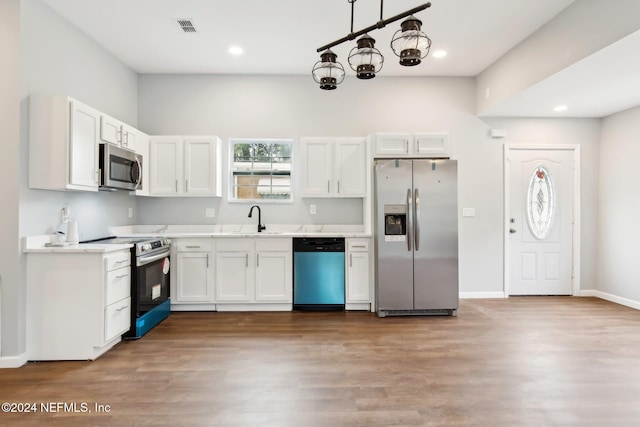 kitchen with white cabinets, stainless steel appliances, and light wood-type flooring