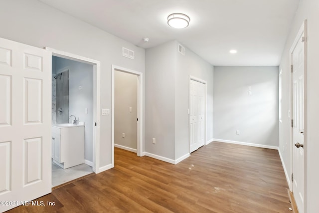 unfurnished bedroom with ensuite bathroom, a closet, light hardwood / wood-style floors, and sink