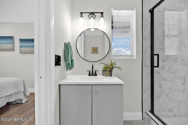 bathroom with hardwood / wood-style flooring, vanity, and an enclosed shower