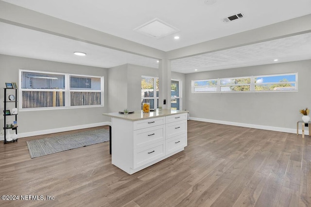 kitchen with a center island, light hardwood / wood-style flooring, and white cabinetry