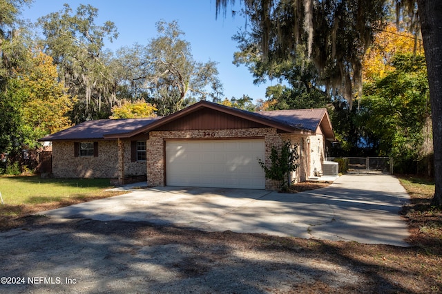 ranch-style home with a garage and central air condition unit