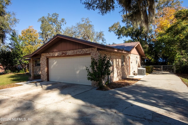 view of side of home featuring central AC and a garage