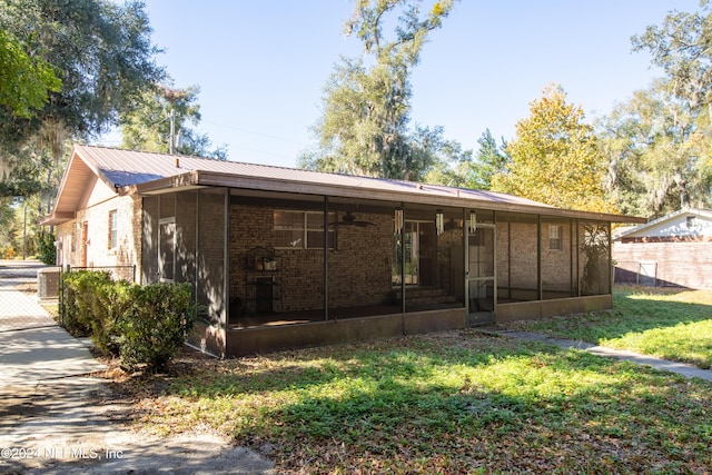 back of house featuring a lawn, central air condition unit, and a sunroom