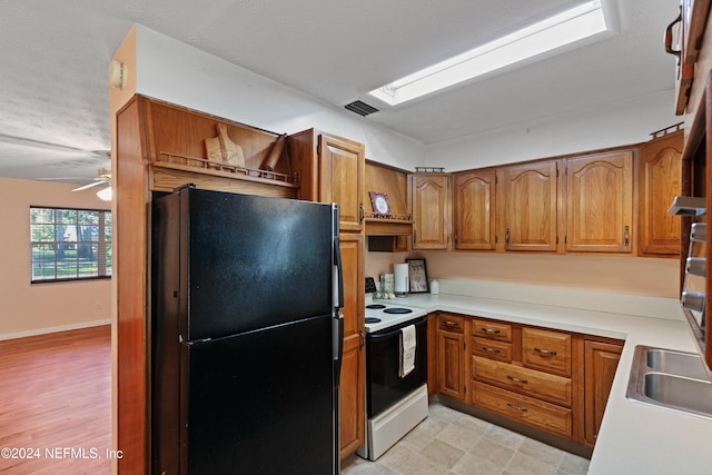 kitchen with electric stove, ceiling fan, and black refrigerator