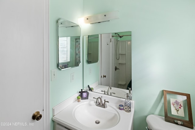 bathroom featuring vanity, an enclosed shower, and toilet