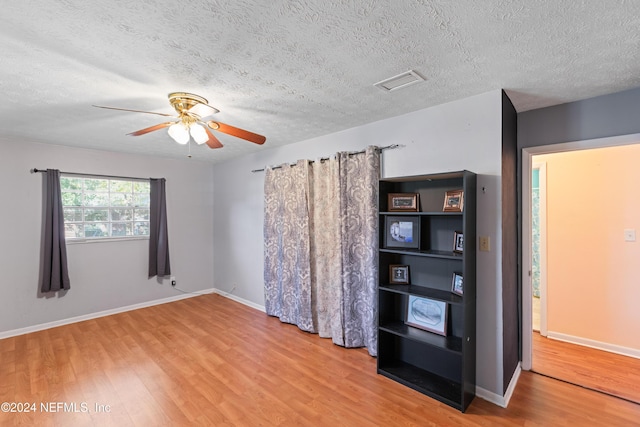 interior space with ceiling fan, wood-type flooring, and a textured ceiling