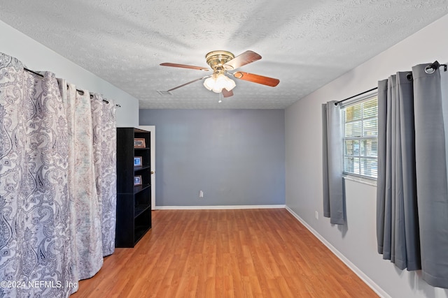 unfurnished room with a textured ceiling, hardwood / wood-style flooring, and ceiling fan