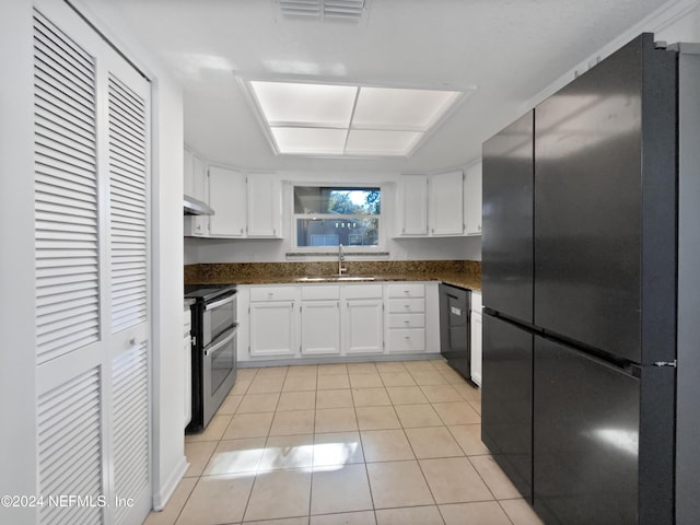 kitchen with black appliances, ventilation hood, sink, light tile patterned flooring, and white cabinetry