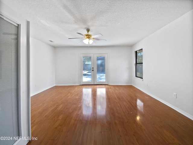 empty room featuring french doors, a textured ceiling, hardwood / wood-style flooring, and ceiling fan